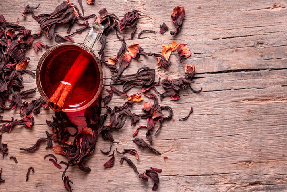Glass Tea Cup on Wood Table filled with Red Tea and Cinnamon Stick